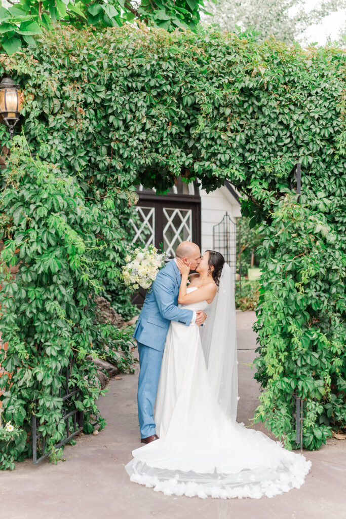 Stephanie and Sam beneath the ivy-covered entrance at The Gatehouse