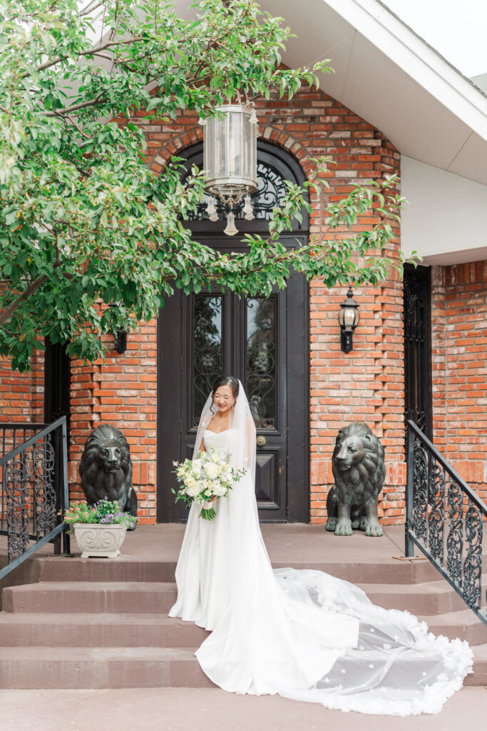 Stephanie in her wedding gown outside the brick entrance to The Gatehouse