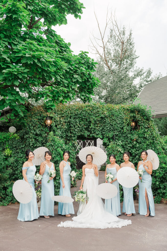 Bridesmaids in soft blue dresses holding white and green bouquets