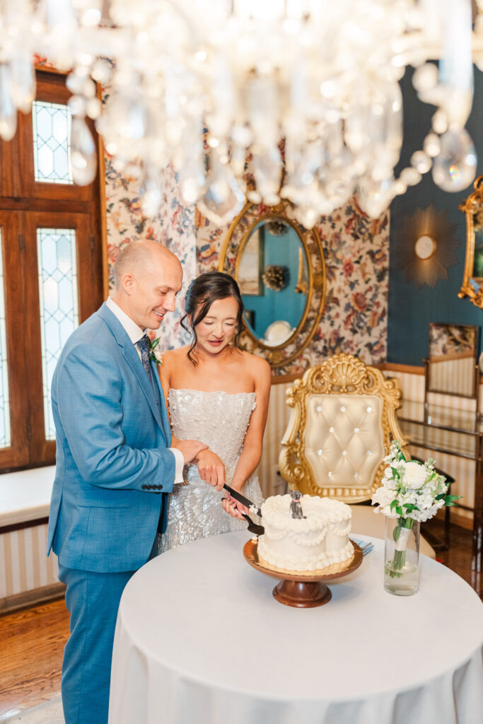 Stephanie and Sam cutting their wedding cake inside The Gatehouse