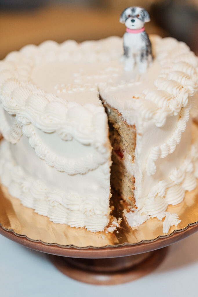 White wedding cake topped with a miniature figure of Lulu