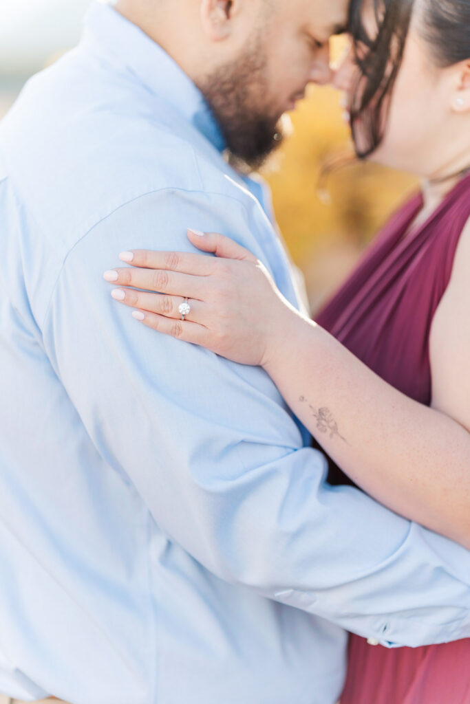 Close-up of Cathie's diamond engagement ring as she embraces Jesse during their engagement session.