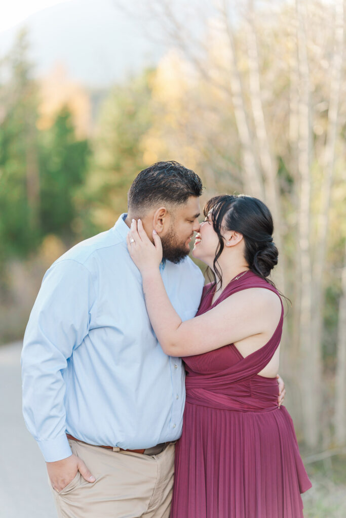 Romantic close-up of Cathie and Jesse leaning together among soft autumn foliage.